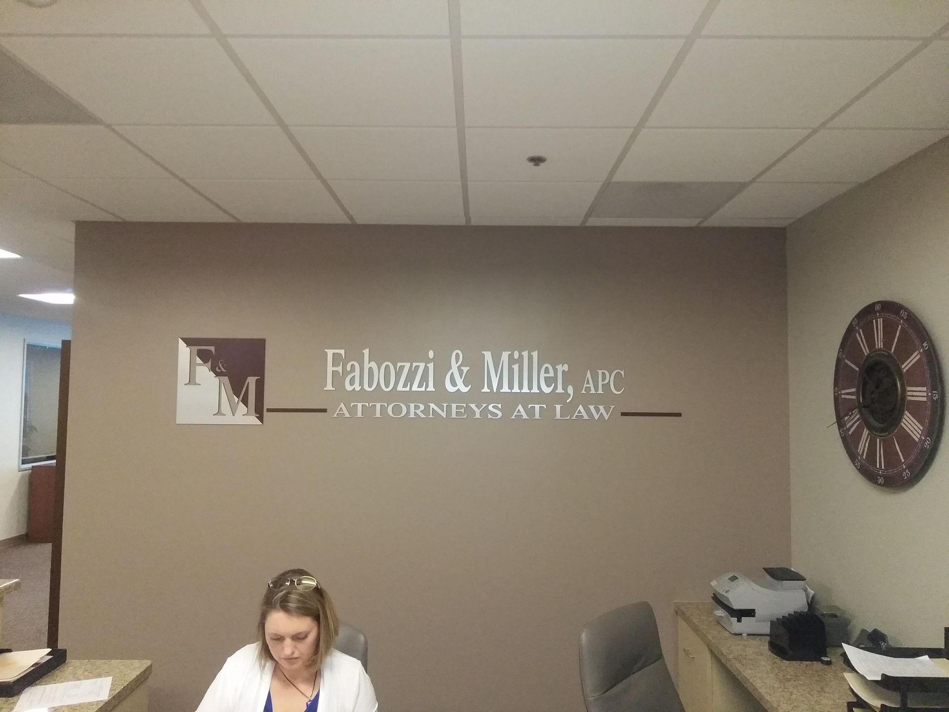 Office reception area with Fabuzzi & Miller law office sign on wall and a desk in the foreground