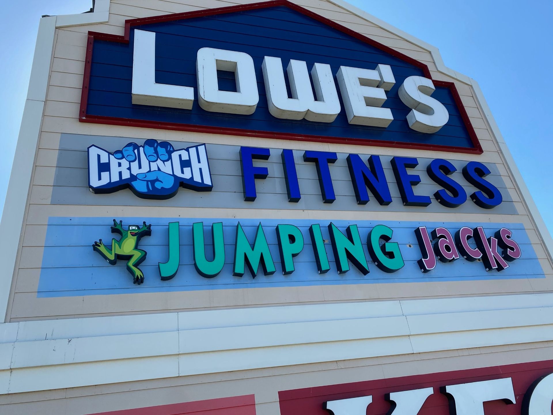 Lowe's sign above Crunch Fitness and Jumping Jacks on a light blue storefront