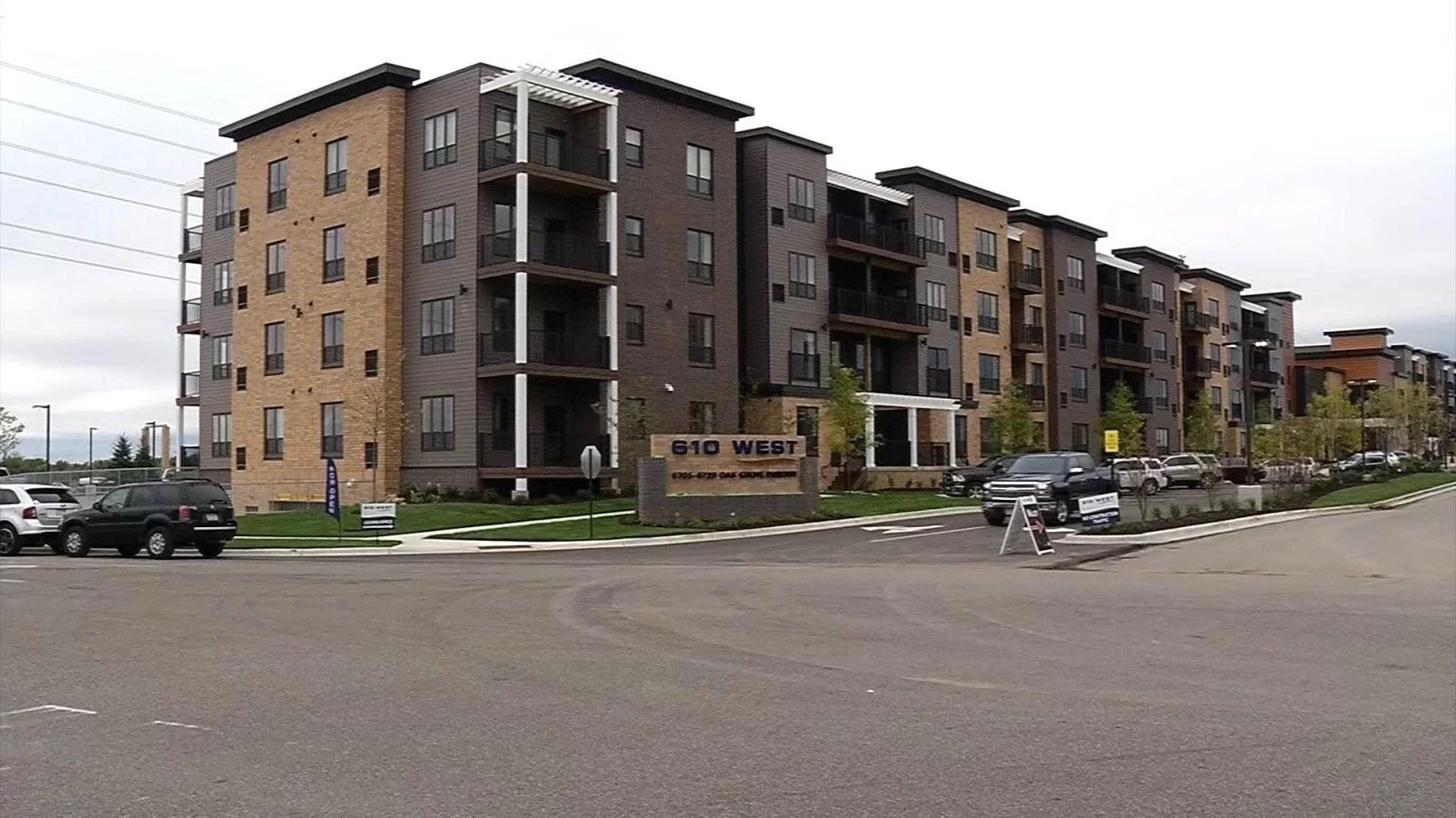 A large apartment building with cars parked in front of it