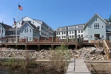 A group of houses sitting next to a body of water with a dock in front of them.