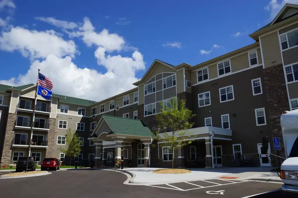 A large apartment building with cars parked in front of it