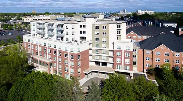 An aerial view of a large apartment building surrounded by trees.