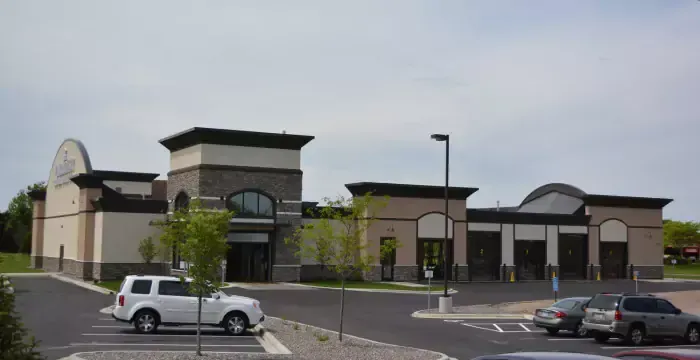 A white suv is parked in front of a large building