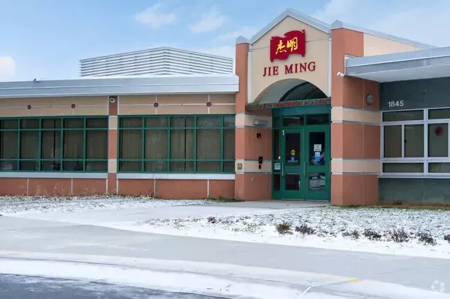 A building with a green door and a sign that says jiu ming