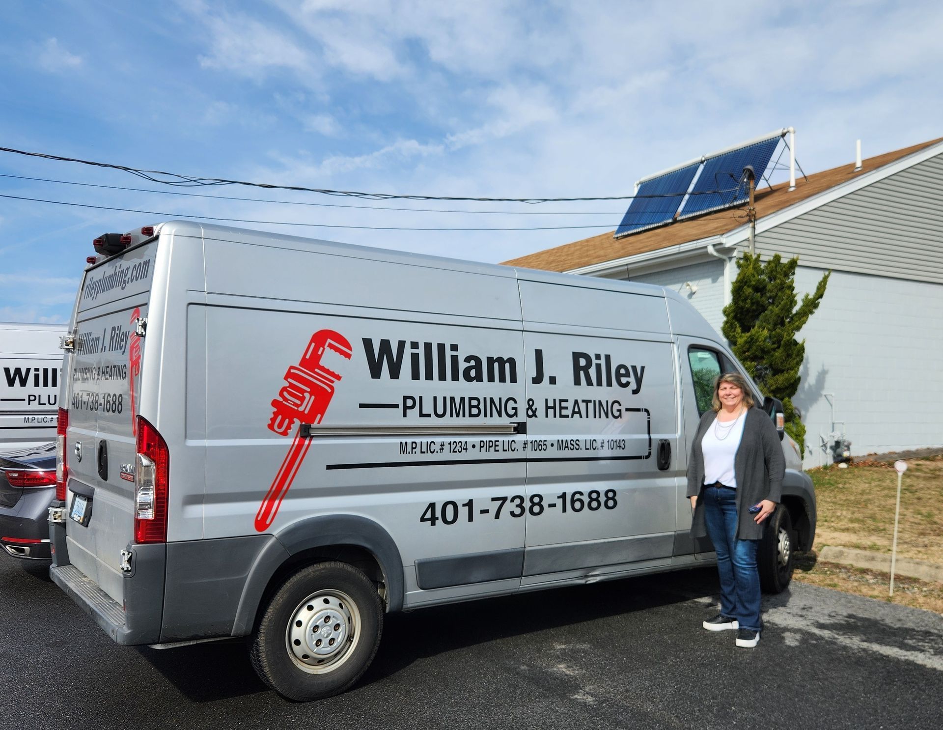 Liz the owner is standing in front of a william j. riley plumbing and heating van