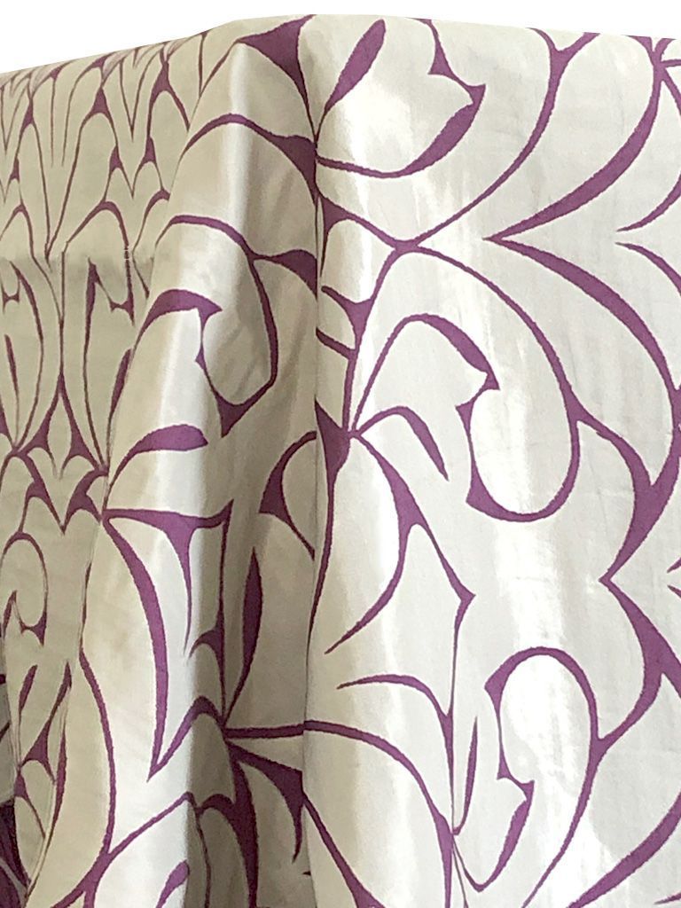 White fabric with purple, abstract, curved pattern.
