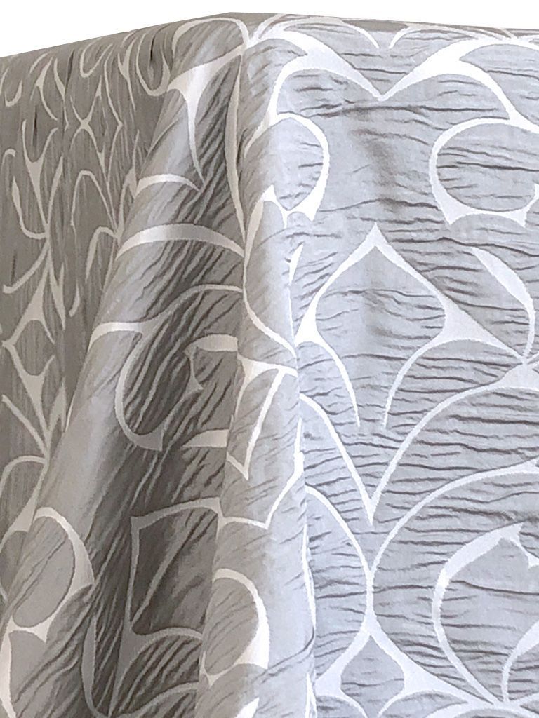 Gray tablecloth with white decorative leaf-like pattern.