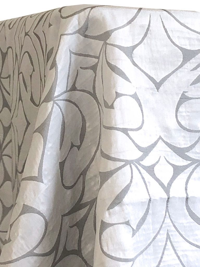 White fabric draped, patterned with gray abstract floral shapes.