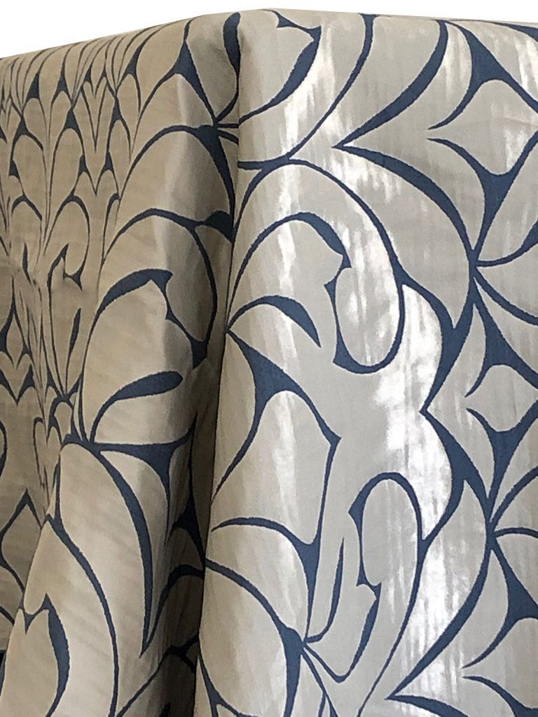 Cream fabric with blue stylized floral pattern.