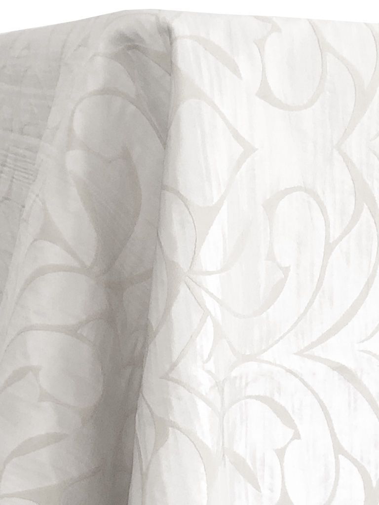 White fabric with a large, swirling floral pattern draped on a surface.