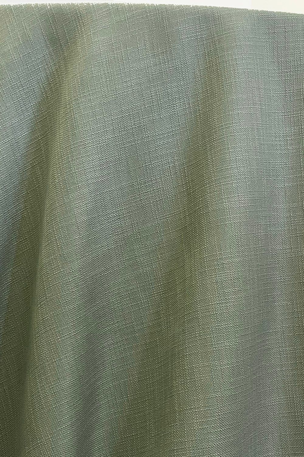 Close-up of a woven fabric in a muted, greenish-gray hue.