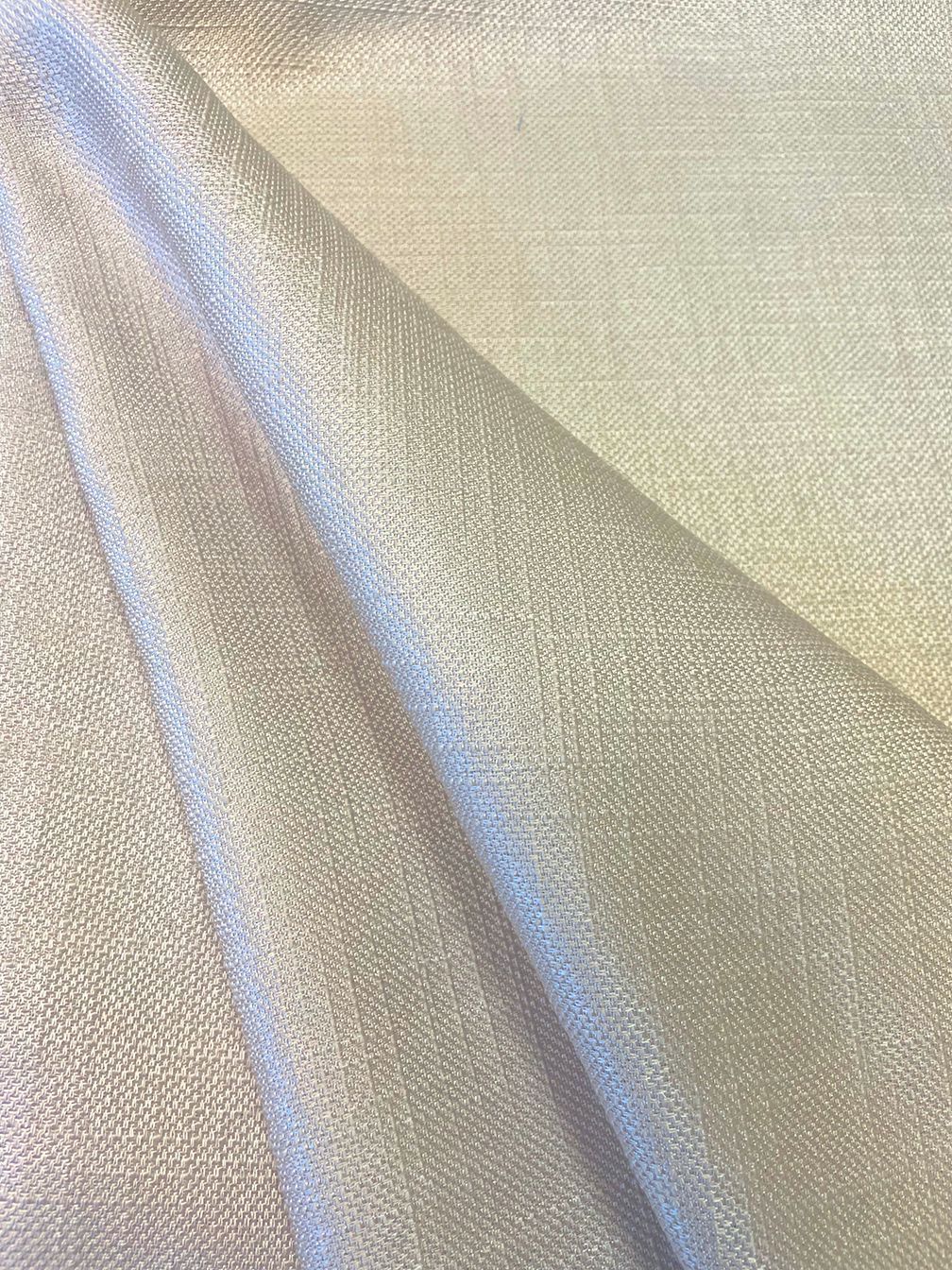 Off-white shimmering fabric, folded, with a woven texture, angled from top left to bottom right.