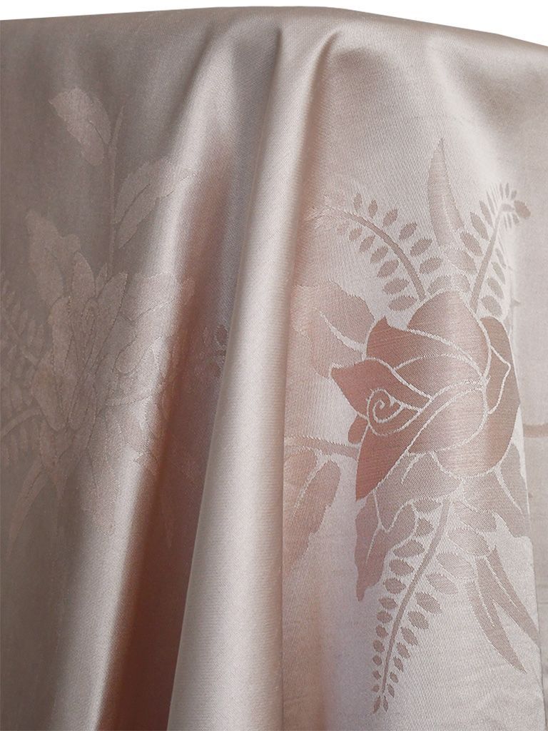 Cream-colored fabric with embossed rose pattern, draped with highlights and shadows.