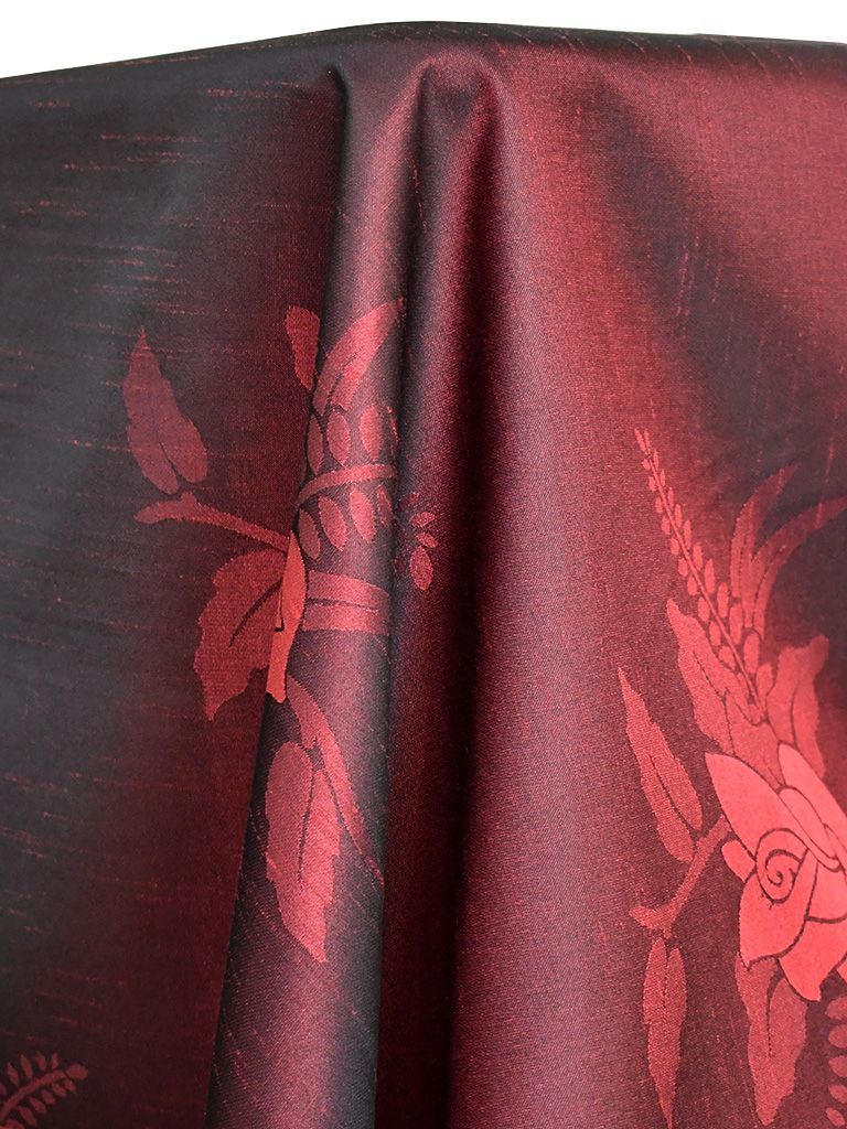 Dark red and black floral patterned fabric with folds.