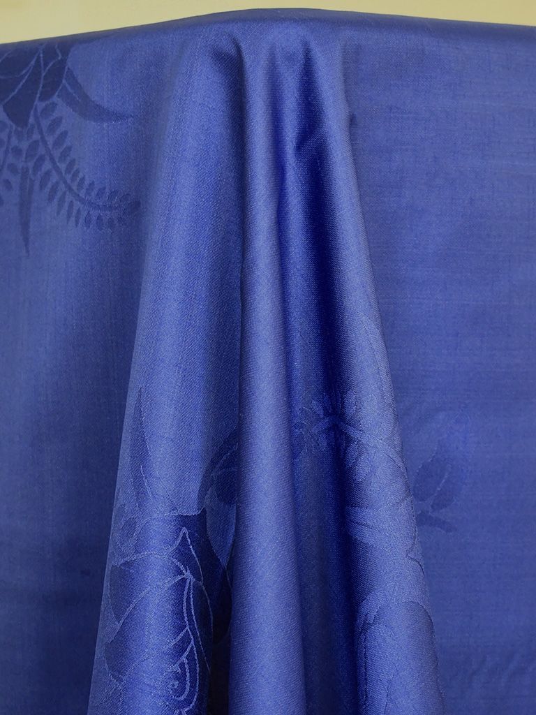 Blue fabric with subtle floral patterns, draped.