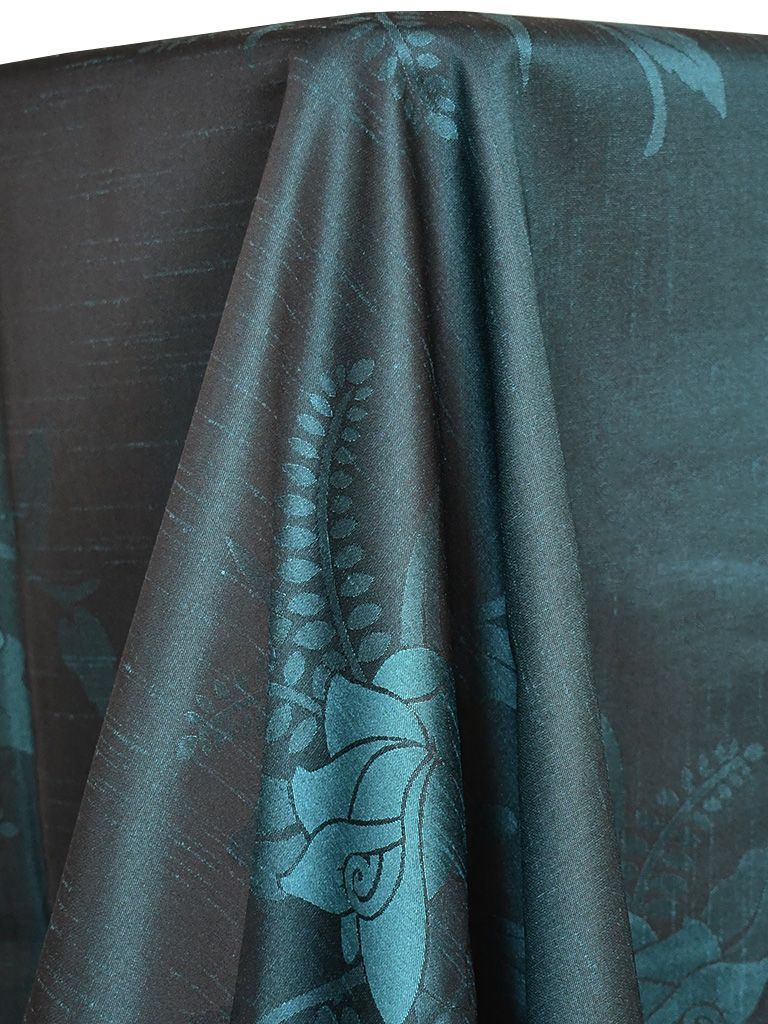 Teal fabric with floral pattern draping over a curved surface.