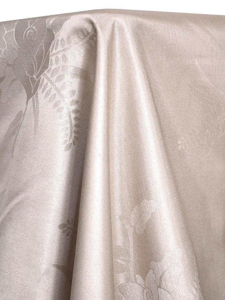 Off-white damask fabric draped, with floral patterns.
