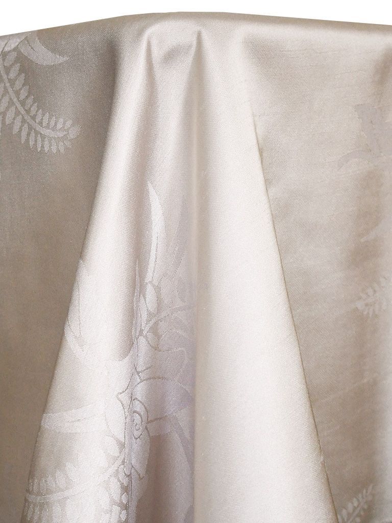 Cream-colored tablecloth with a subtle floral pattern, draped over a surface.