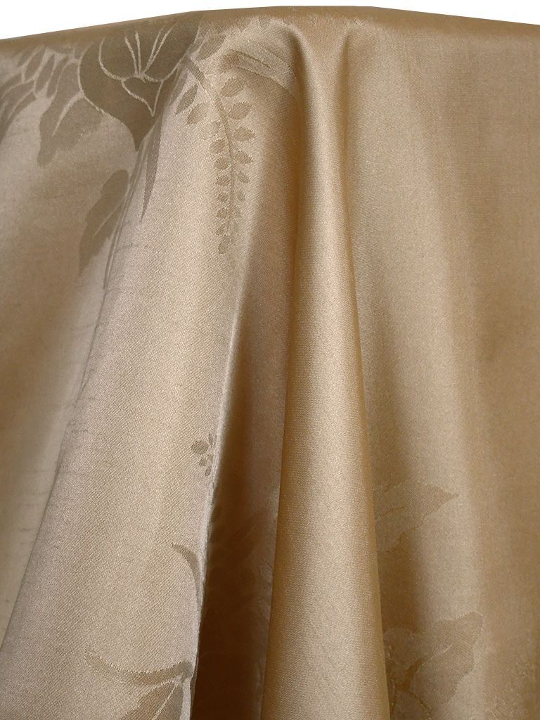 Beige tablecloth with floral pattern, draped over a table.