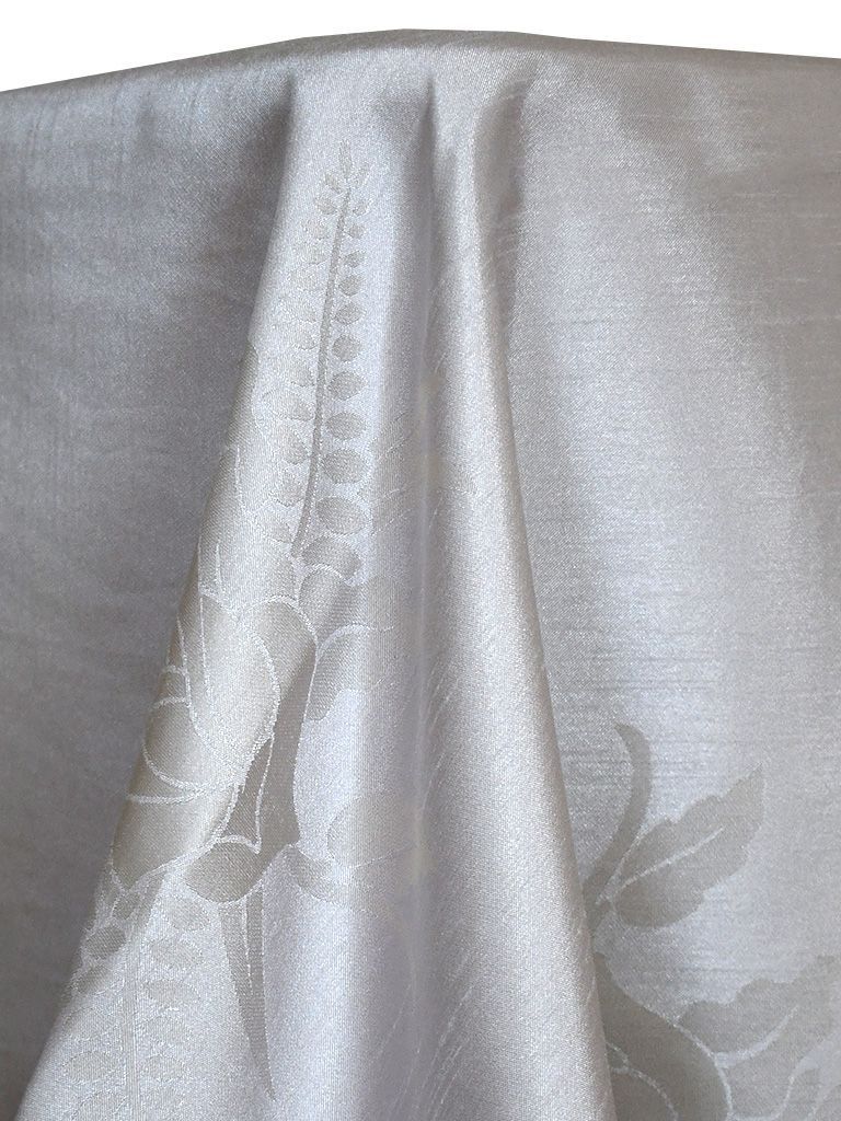 White tablecloth with floral pattern, draped, capturing light.