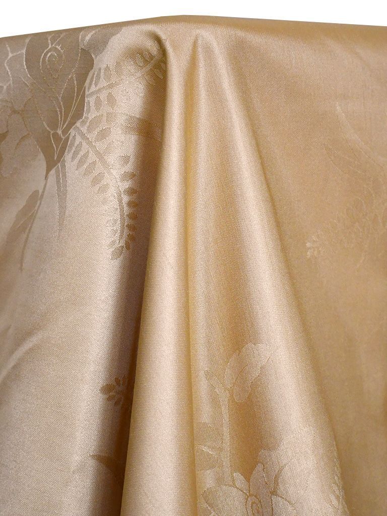 Beige damask fabric draped, featuring floral patterns and soft folds.