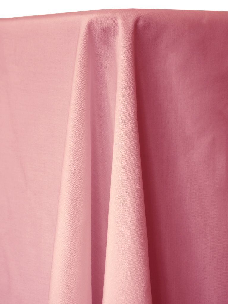 Pink tablecloth draped over a table, fabric texture visible.