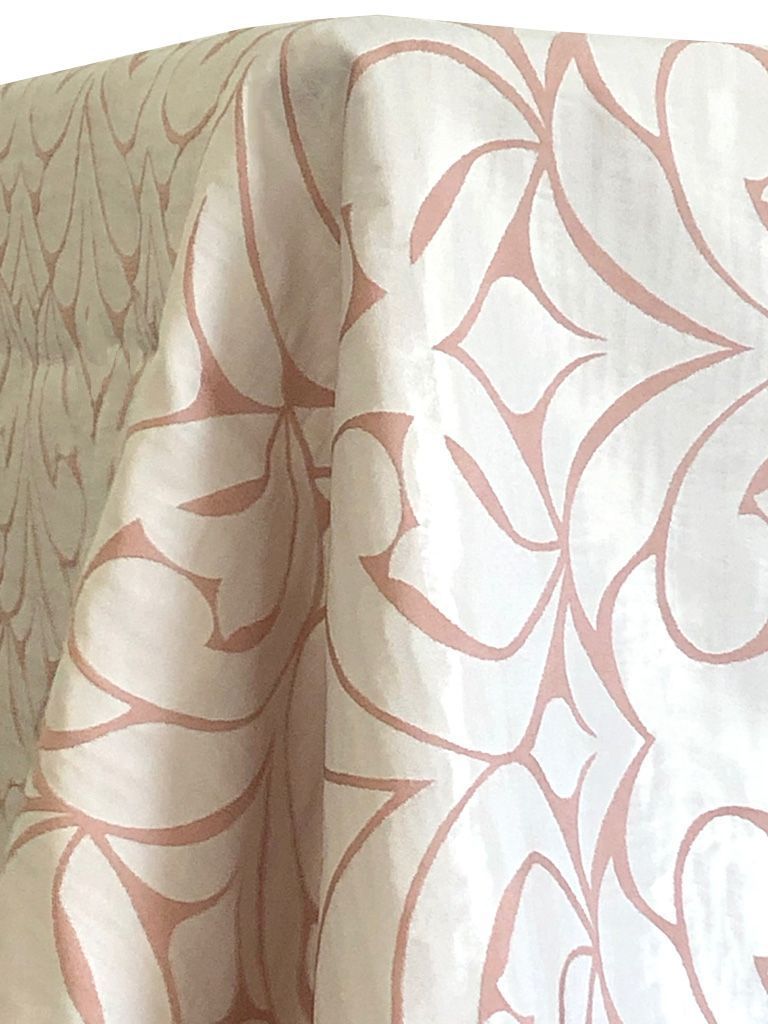 White fabric with pink floral pattern, draped.