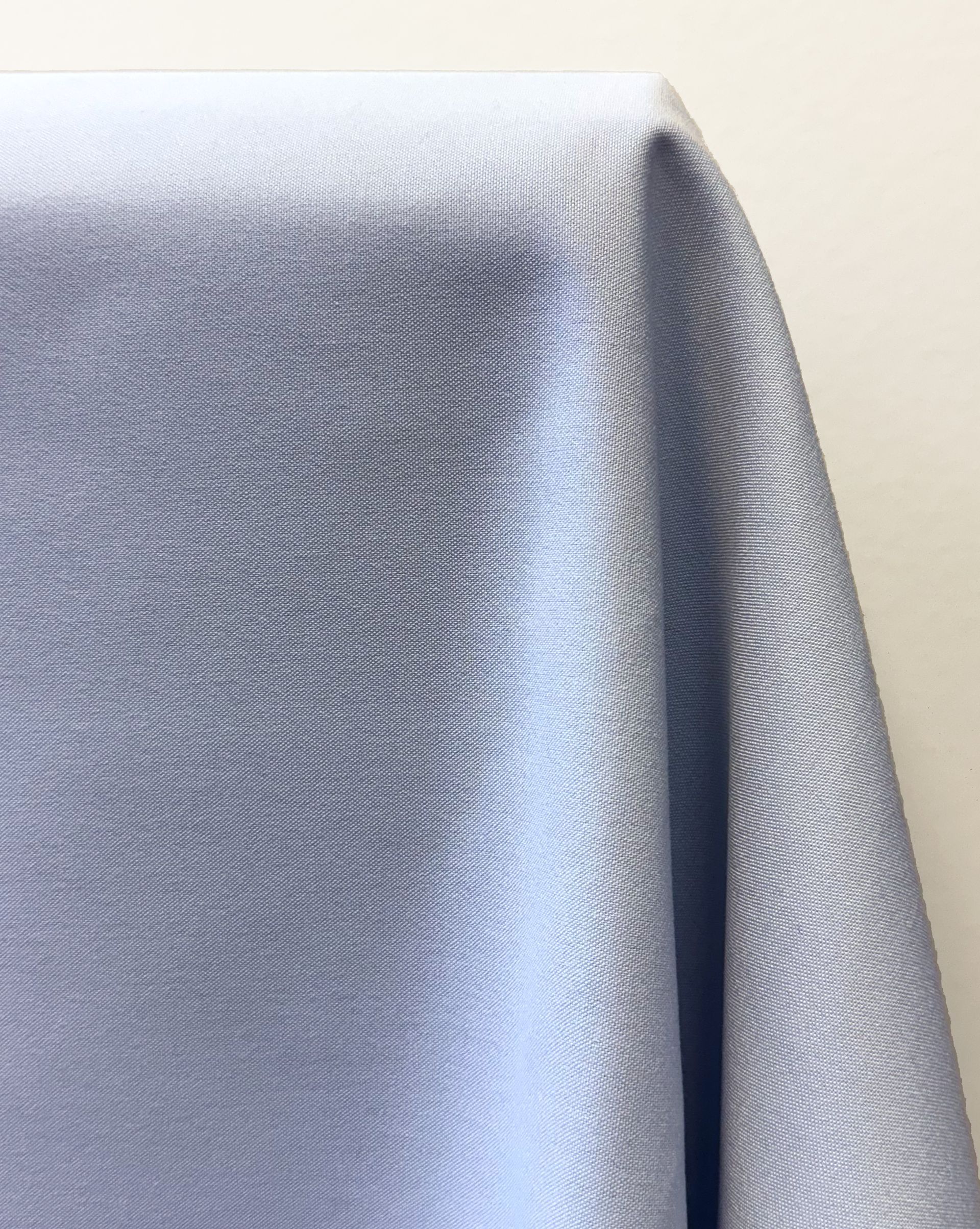 Blue fabric with diagonal ribbing draped against a white surface.