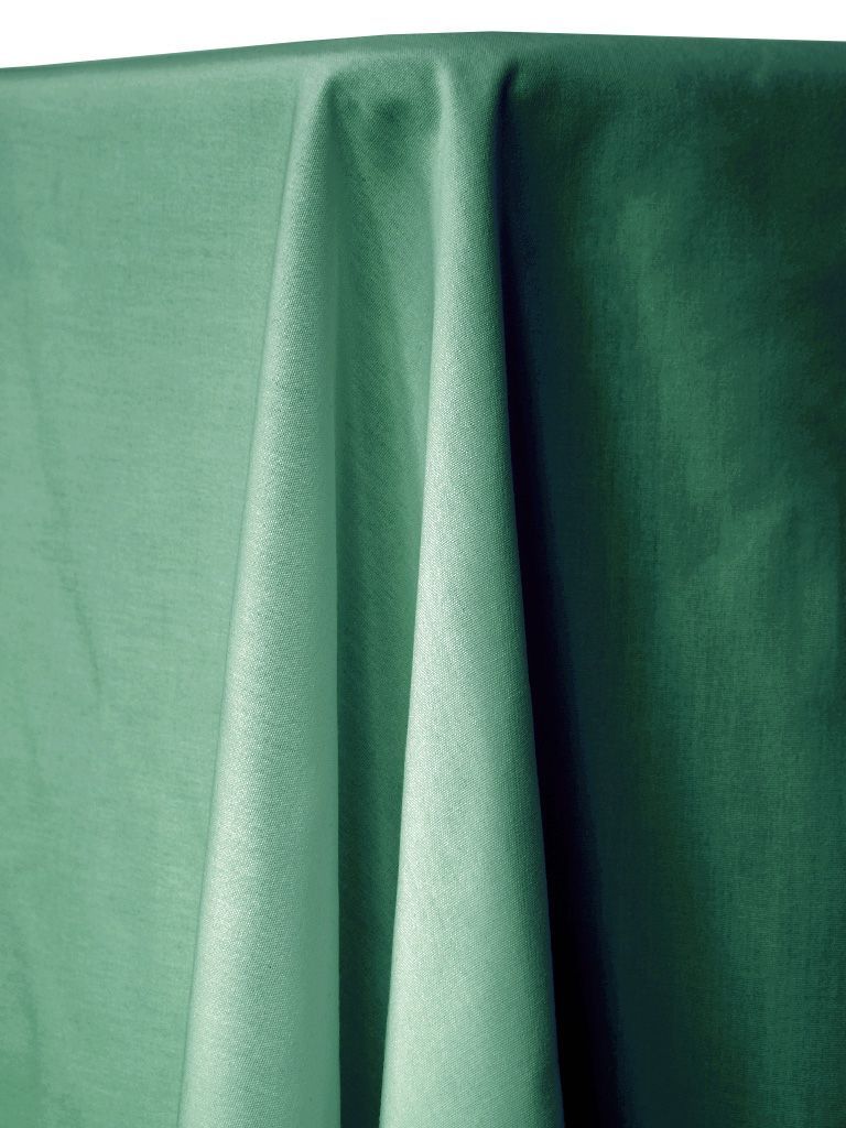 A draped green tablecloth with a textured surface, possibly linen, over a table.