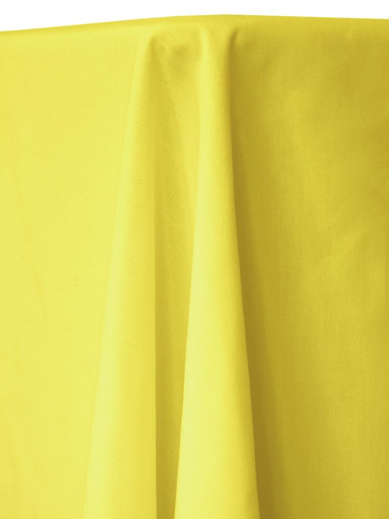 Yellow fabric draped over a table, creating soft folds and shadows.