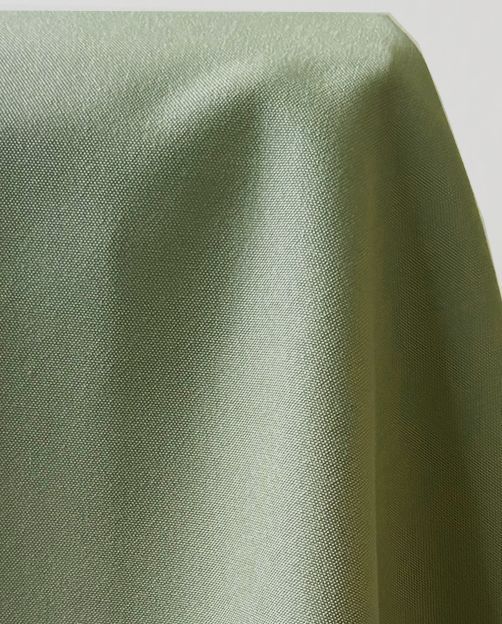 Close-up of draped light green fabric with subtle texture and highlights.