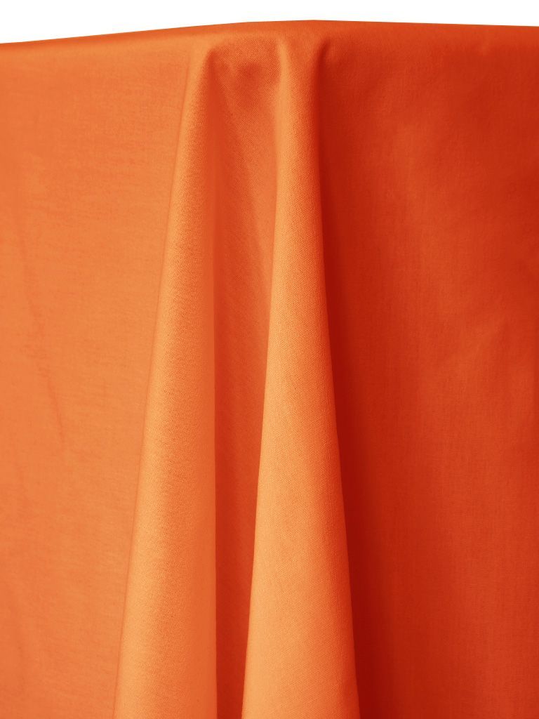 Bright orange tablecloth draped over a table, with visible folds and textures.