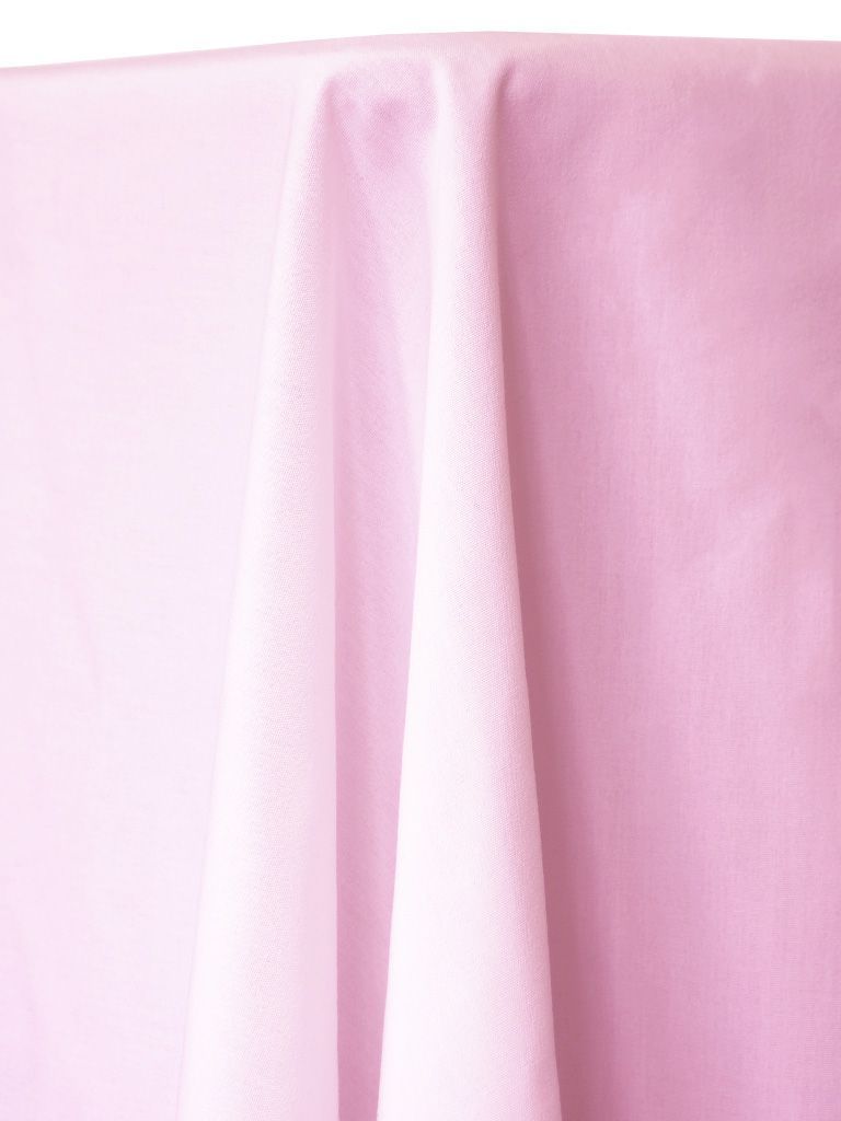 Pink tablecloth draped over a table, with folds and shadows.
