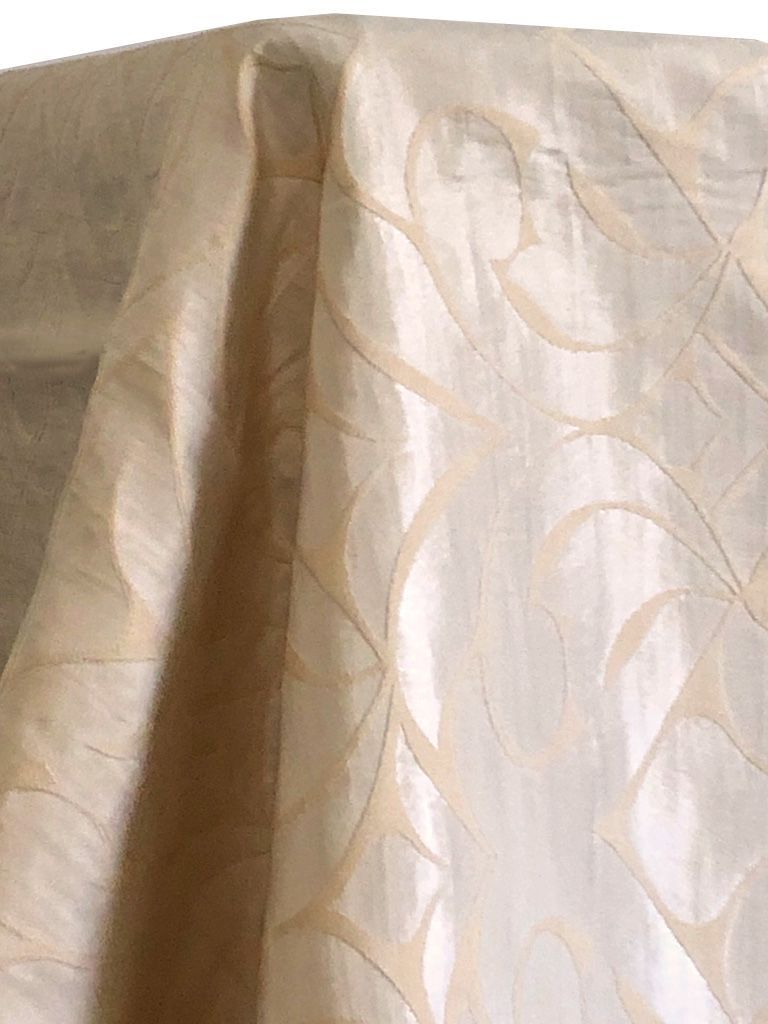 Beige and cream patterned fabric draped over an unseen object, with a shiny, silky appearance.