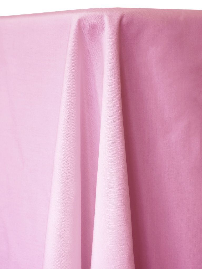 Pink tablecloth draped over a table, fabric folds visible.