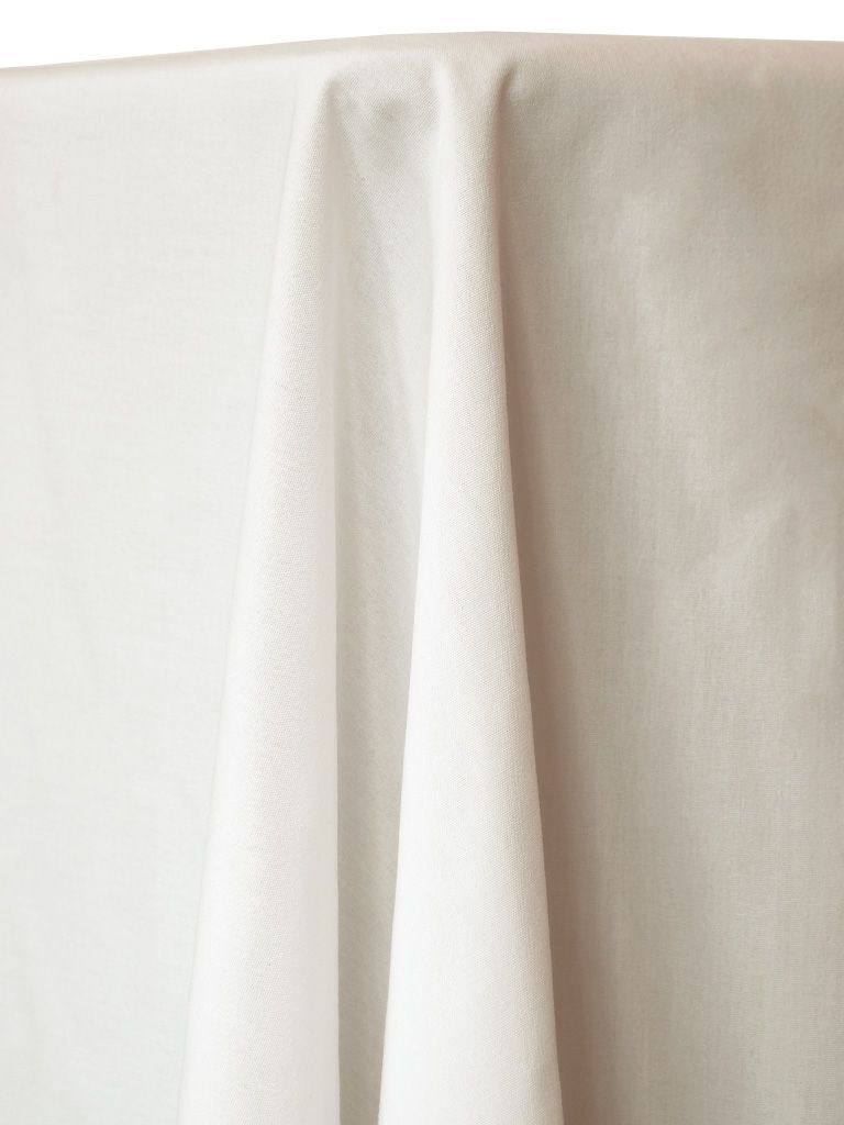 White tablecloth draped over a table, with folds and shadows.