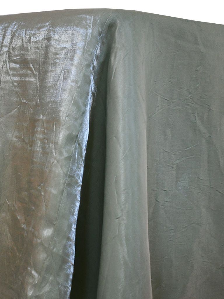 Green fabric with a subtle pattern, draped on a surface.