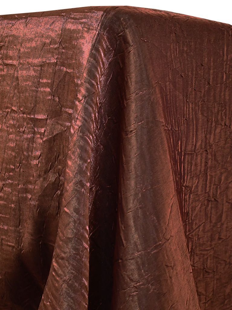 Close-up of a draped, textured burgundy-colored tablecloth.