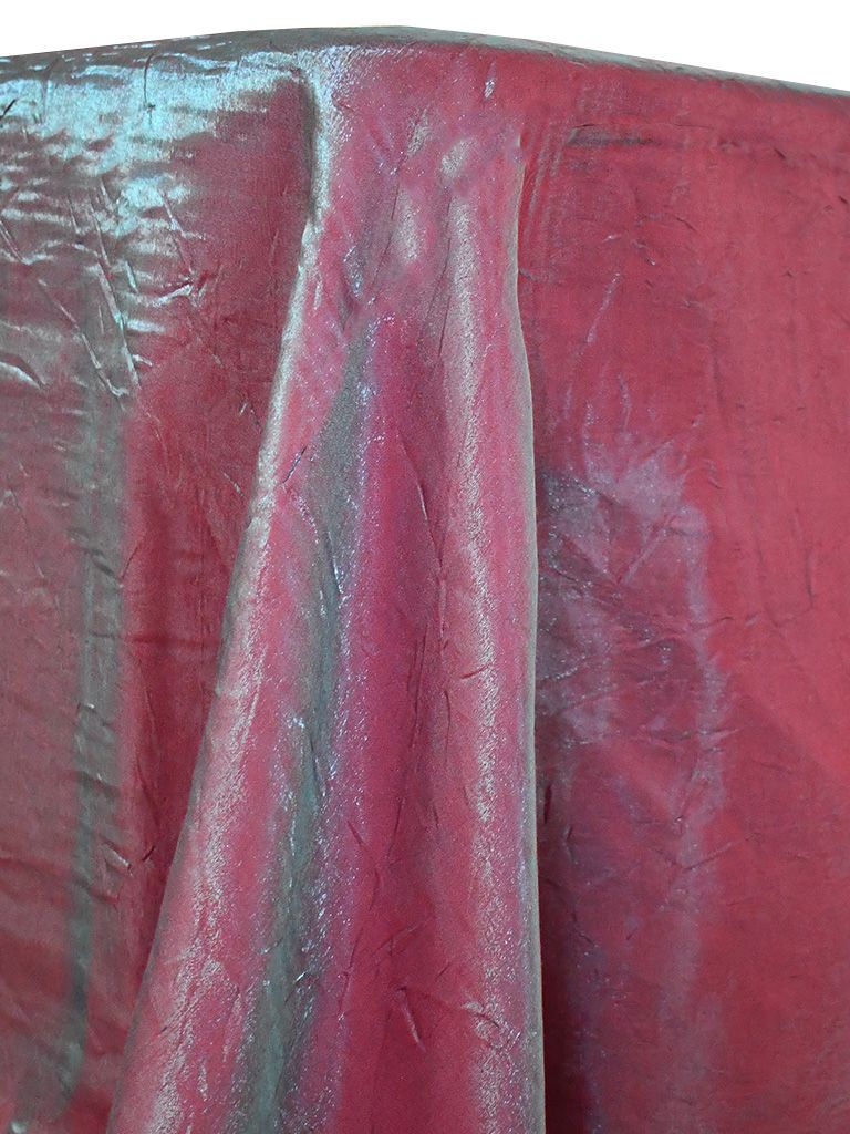 Iridescent red fabric draped over a surface, with hints of blue and purple.