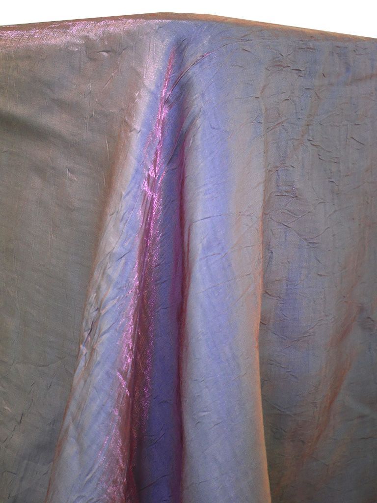 Purple and silver shimmery fabric draped over a surface, with highlights of pink.