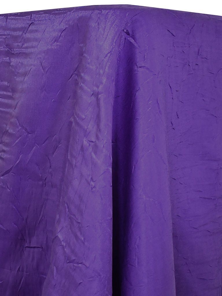 Purple textured fabric draped over a round surface.
