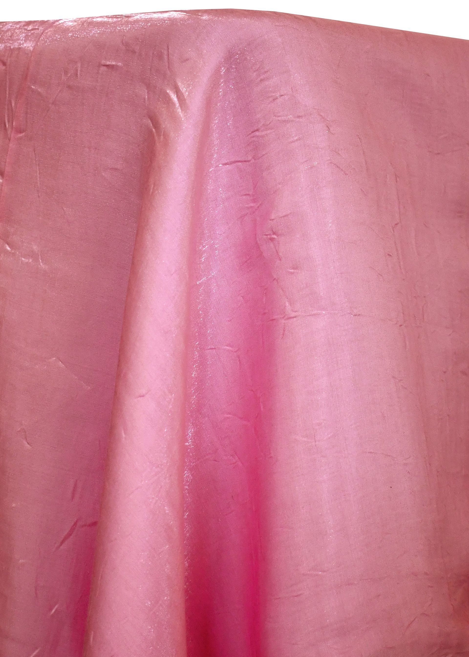 Pink fabric draped over a surface, with highlights and texture.