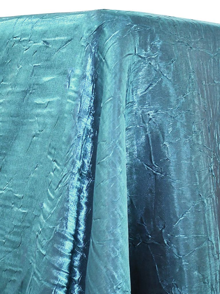 Teal crushed taffeta tablecloth, textured, draped over a surface, with folds.