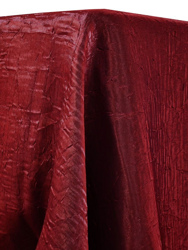 Red textured fabric draping over a surface.
