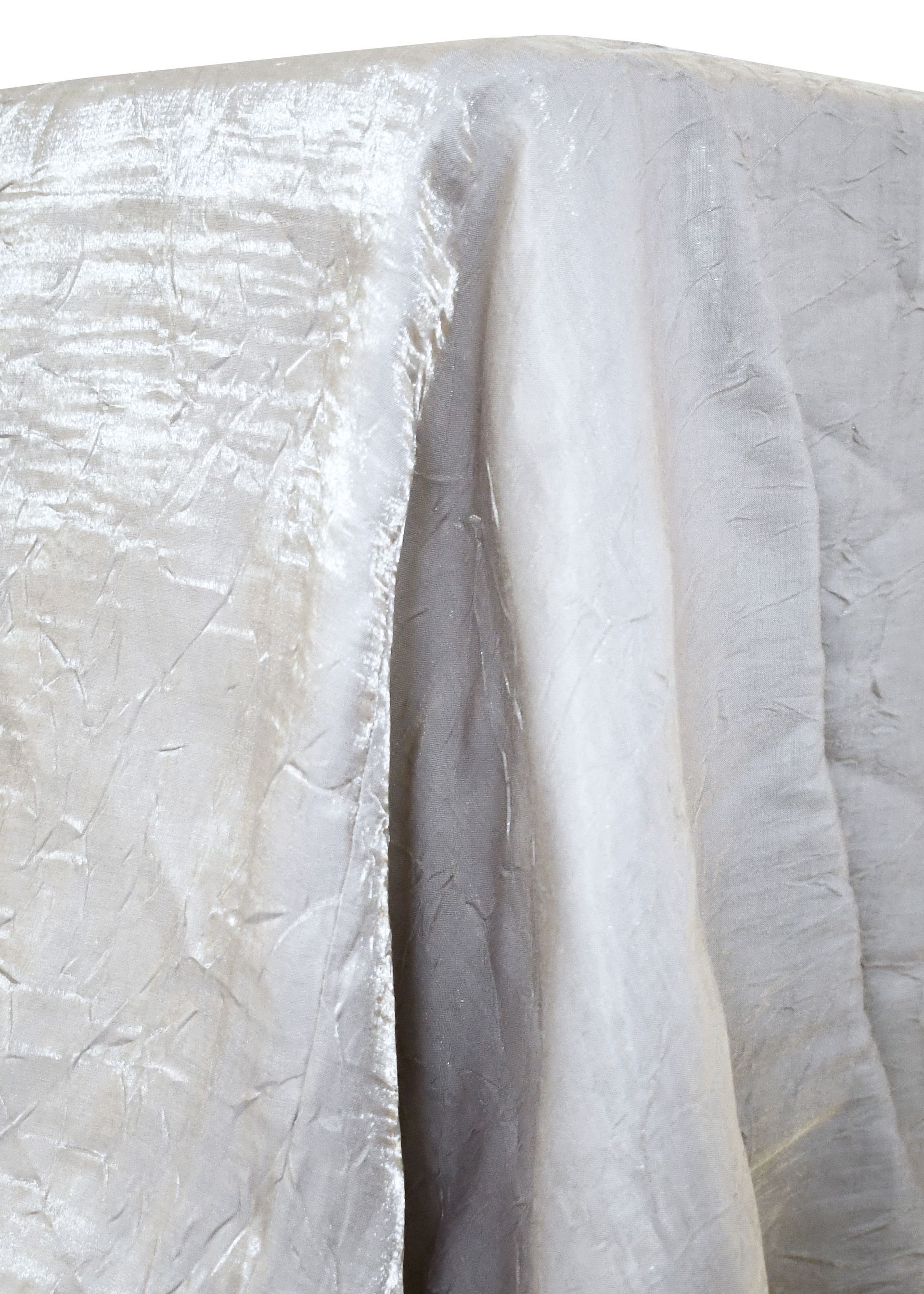 Silver crushed fabric tablecloth draped over a table, with visible wrinkles.