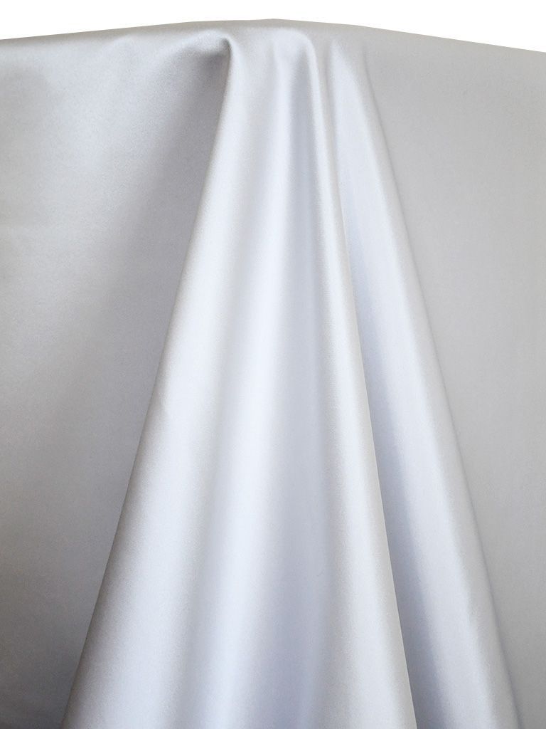 White satin fabric draped over a surface, with folds creating shadows.