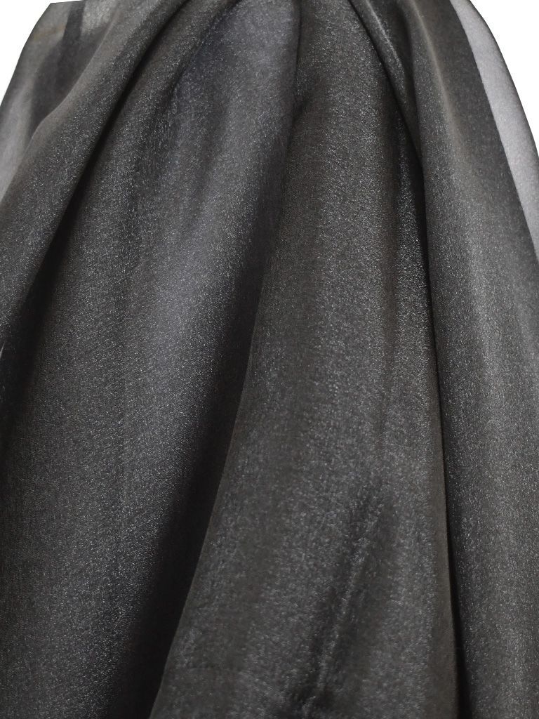 Black, shimmering fabric draped, creating folds and highlights.