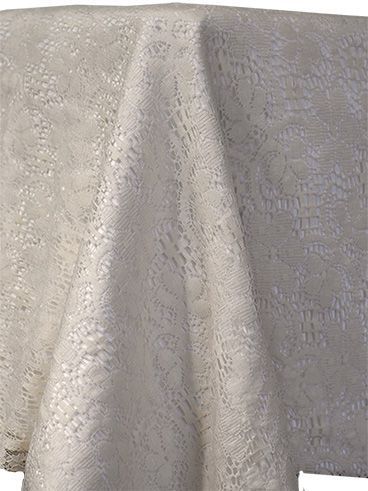 White lace fabric draped over an unseen object, showing intricate details.