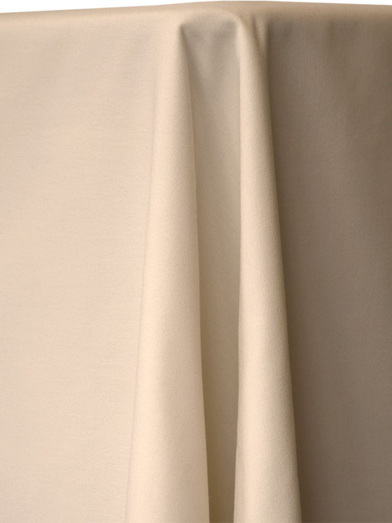 Beige fabric draped over a surface, with folds creating shadows and texture.