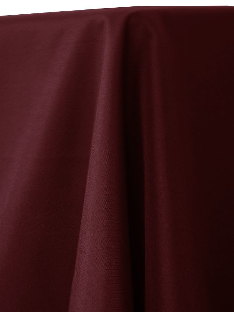 Close-up of a burgundy fabric tablecloth with soft folds.